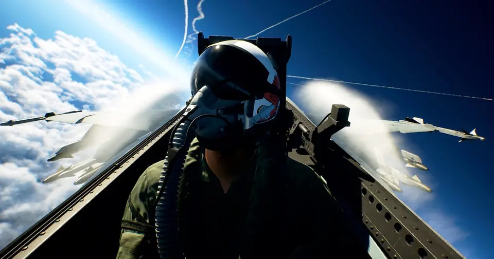 A first-person view from the cockpit of a fighter jet high above the clouds in Ace Combat 8: Wings of Theve, the pilot's helmet visor reflecting the sky