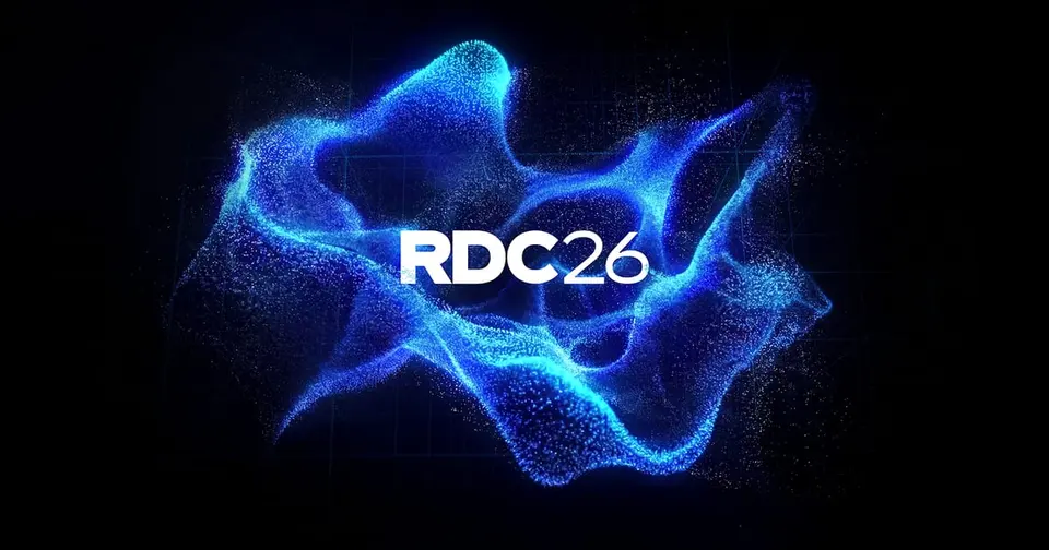 RDC26 key art with a glowing blue particle wave on a dark grid background and the white RDC26 wordmark in the center